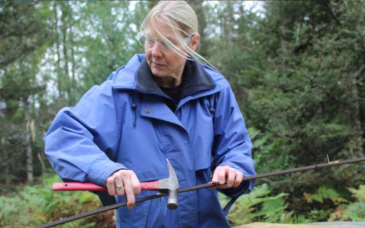 A person uses a hammer during a service project with Outward Bound.
